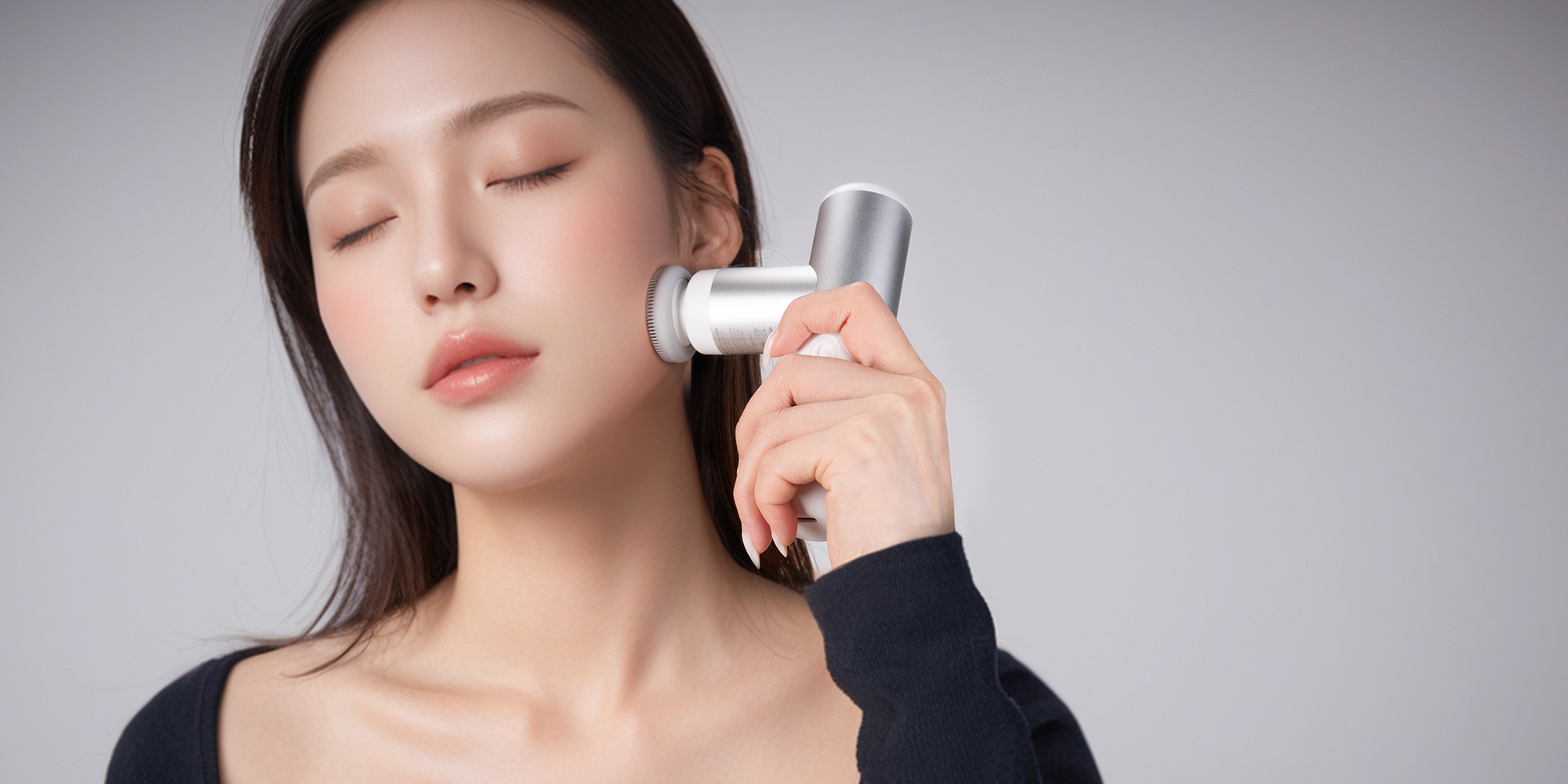 Masażer wibracyjny KiCA mini 3 - biały używany przez kobietę na twarzy